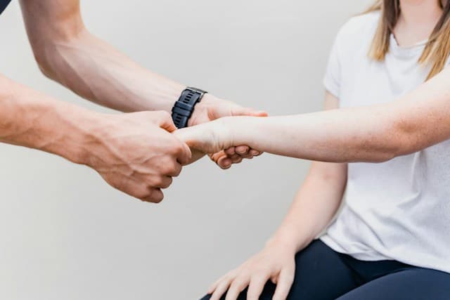Un kinésithérapeute examine le poignet d’un patient